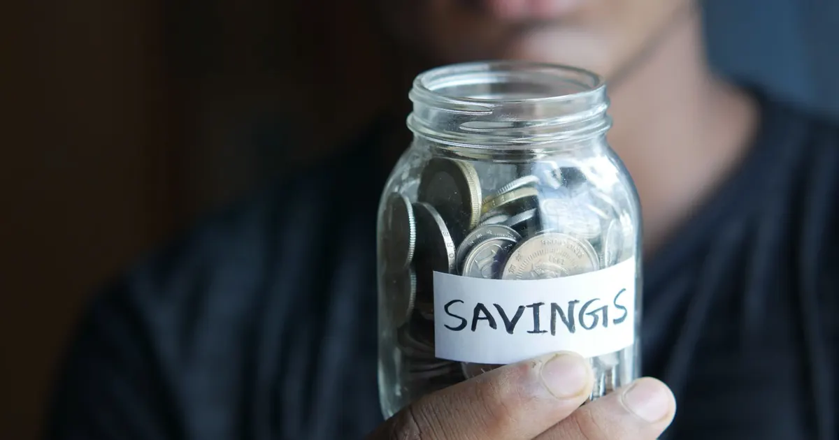 Frasco de ahorros entre las manos — abono a capital en el crédito hipotecario en Colombia 2026