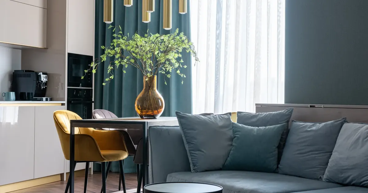 Apartamento amoblado vs sin amoblar: cuál rinde más Sala moderna amoblada con sofá, comedor y cocina integrada — apartamento amoblado vs sin amoblar rentabilidad 2026