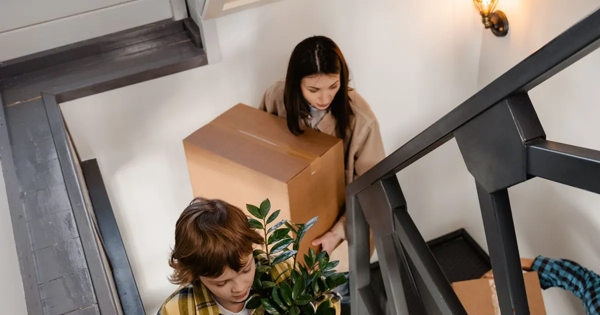 Cesantías para comprar vivienda en Colombia 2026 Familia cargando cajas al entrar a su nueva casa — cesantías para comprar vivienda en Colombia 2026