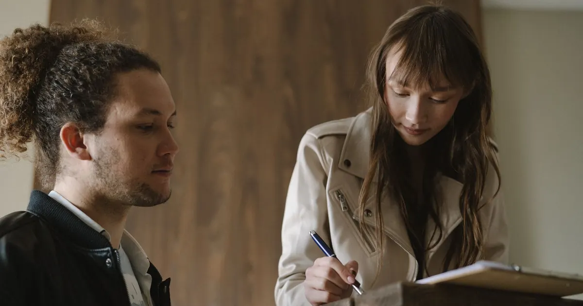 Pareja revisando y firmando documentos de arriendo — contrato de arrendamiento en Colombia 2026
