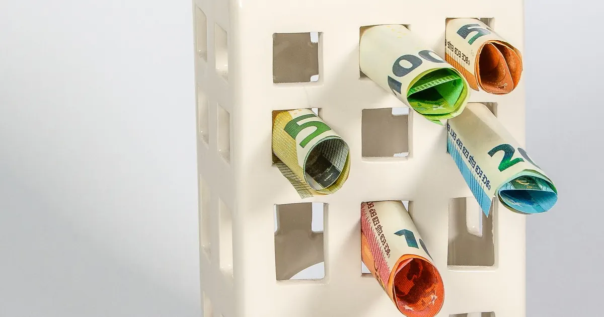 Alcancía en forma de edificio con billetes — cuota inicial de un apartamento en Colombia 2026