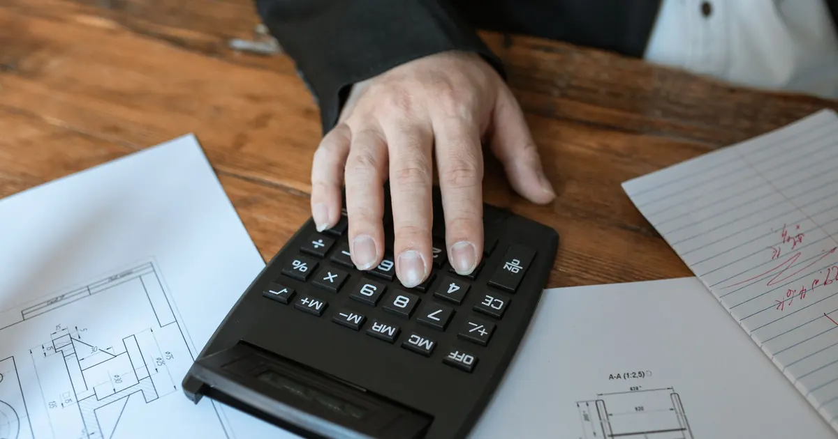 Calculadora y planos sobre una mesa — errores al calcular la rentabilidad de un inmueble