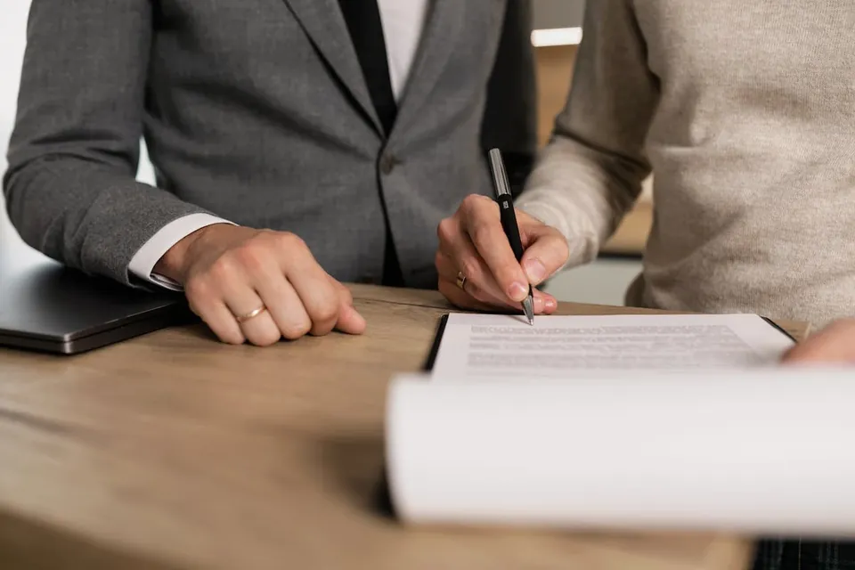 Decreto 2590 de 2009 explicado para arrendadores Firma de un contrato de arrendamiento sobre un escritorio — Decreto 2590 de 2009 y arrendadores
