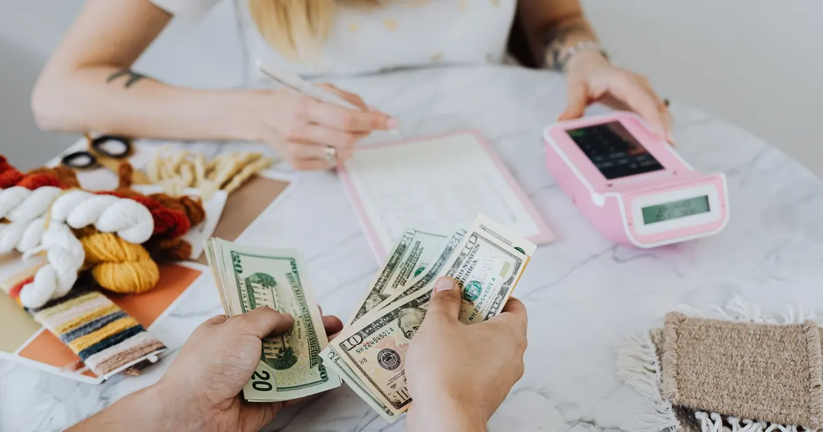Manos contando dinero junto a una calculadora — flujo de caja inmobiliario en Colombia 2026