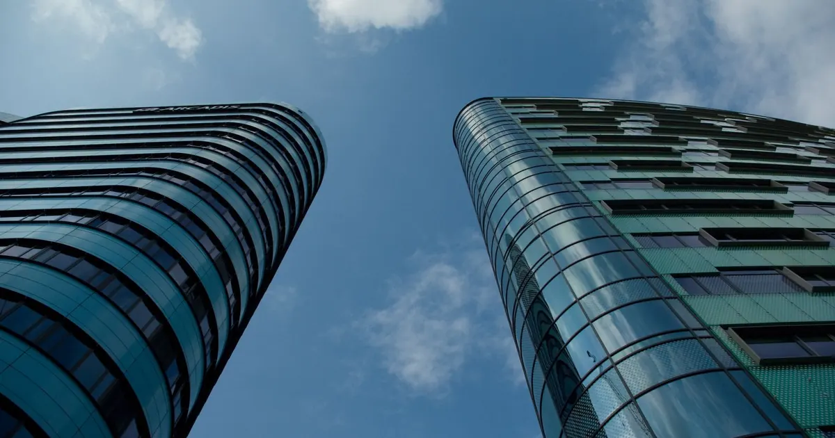 Torres de oficinas de vidrio vistas desde abajo — fondos de inversión inmobiliaria en Colombia 2026