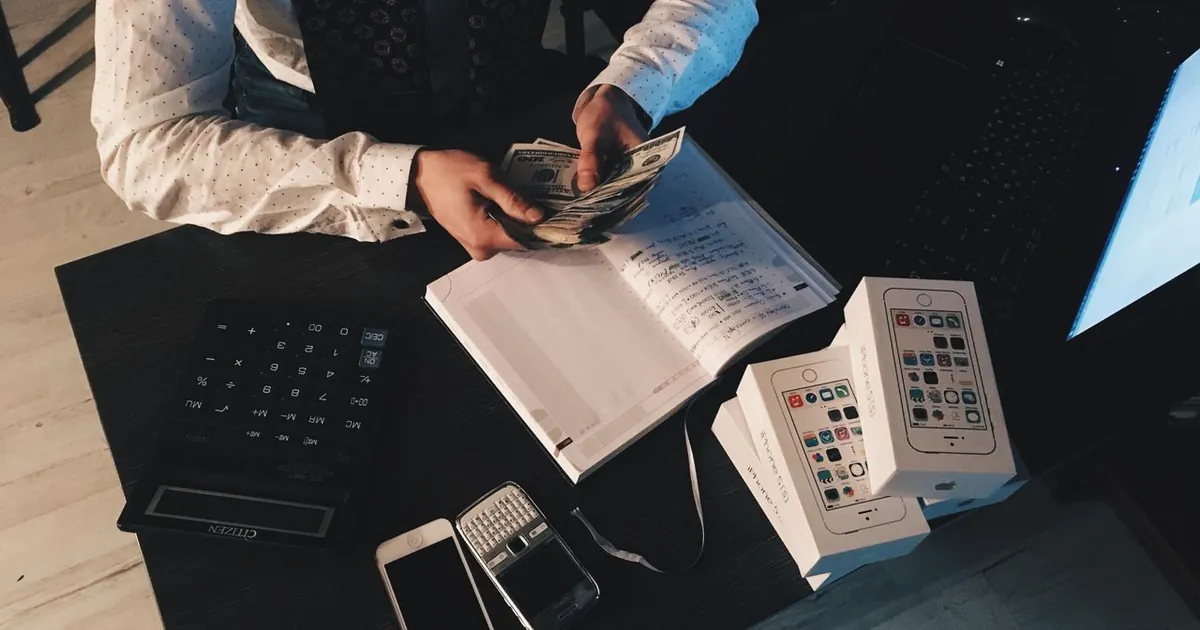 Conteo de dinero con cuaderno y calculadora — gestión de gastos inmobiliarios 2026