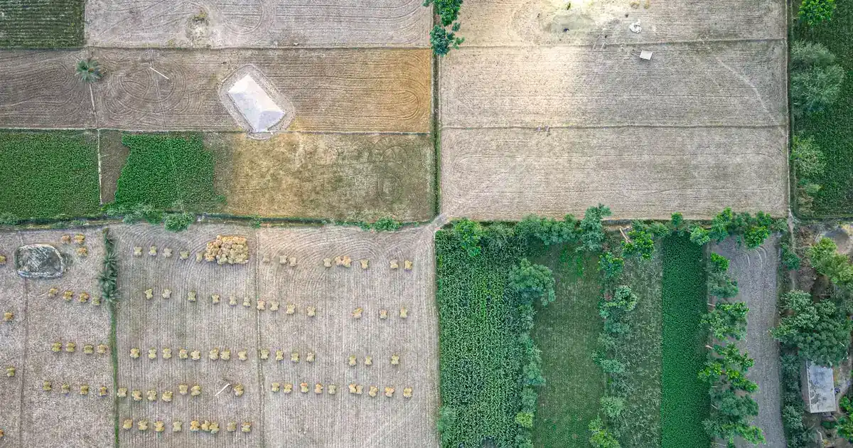 Invertir en lotes en Colombia 2026: riesgos y retorno Vista aérea de lotes y terrenos divididos en el campo — invertir en lotes en Colombia 2026
