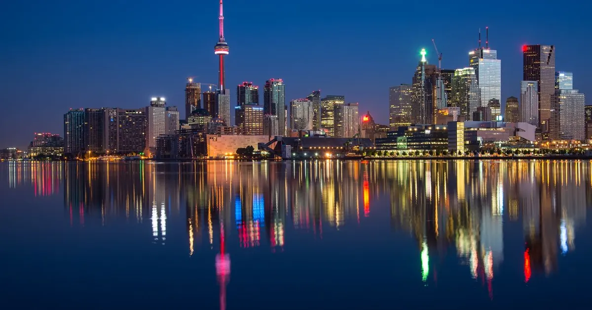 Skyline de ciudad de noche sobre el agua — análisis del mercado inmobiliario Colombia 2026