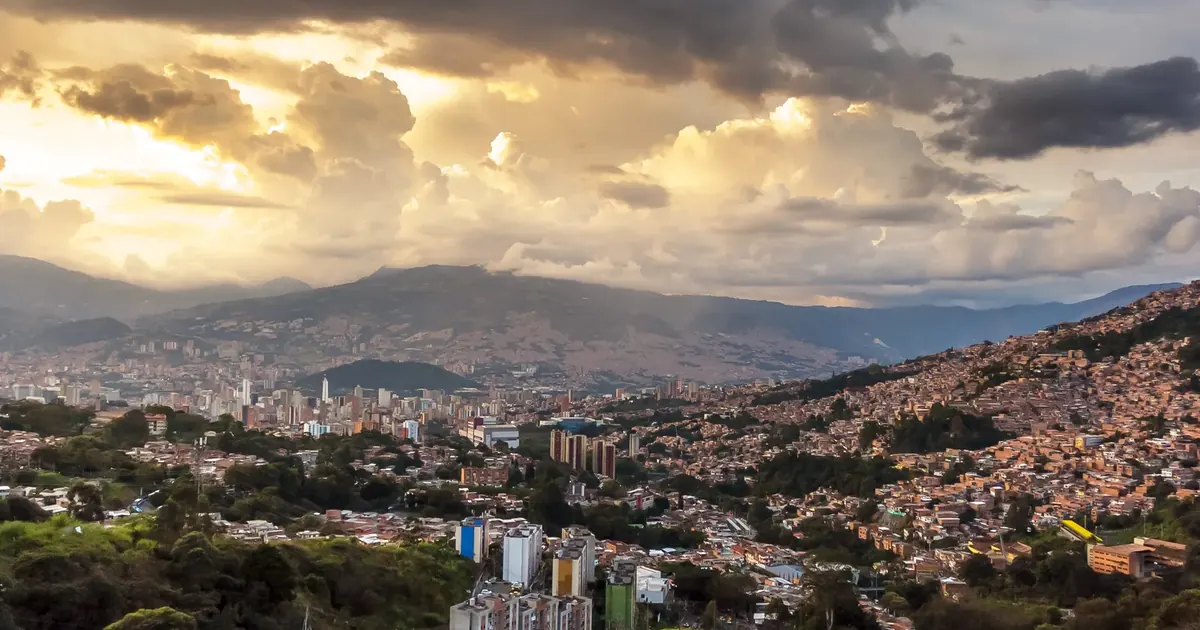 Vista panorámica del valle de Aburrá al atardecer con barrios de ladera y torres — precio del metro cuadrado en Medellín 2026
