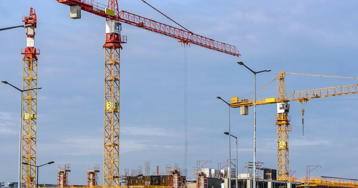 Grúas torre en una obra de construcción — vivienda sobre planos en Colombia